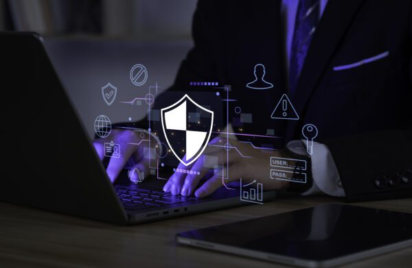 Businessman using laptop computer with digital padlock representing authentication processes