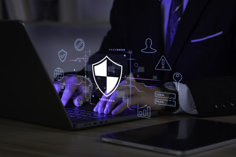 Businessman using laptop computer with digital padlock representing authentication processes