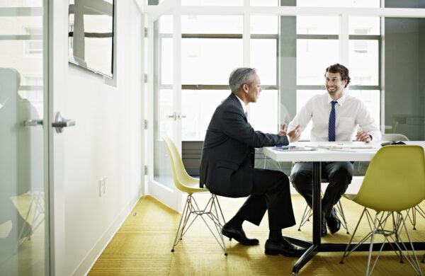 Friendly hiring manager interviewing a potential employee in an office conference room