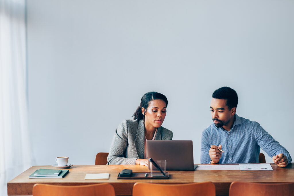 A knowledgeable mentor guiding a mentee trainee in a professional office setting