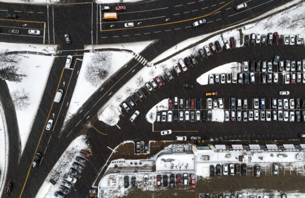 Aerial view of a shopping mall parking lot during a winter snowstorm