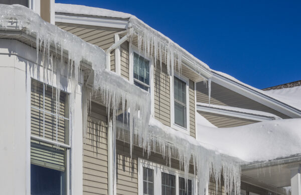 Ice dams and snow on roof and gutters after bitter cold and winter weather