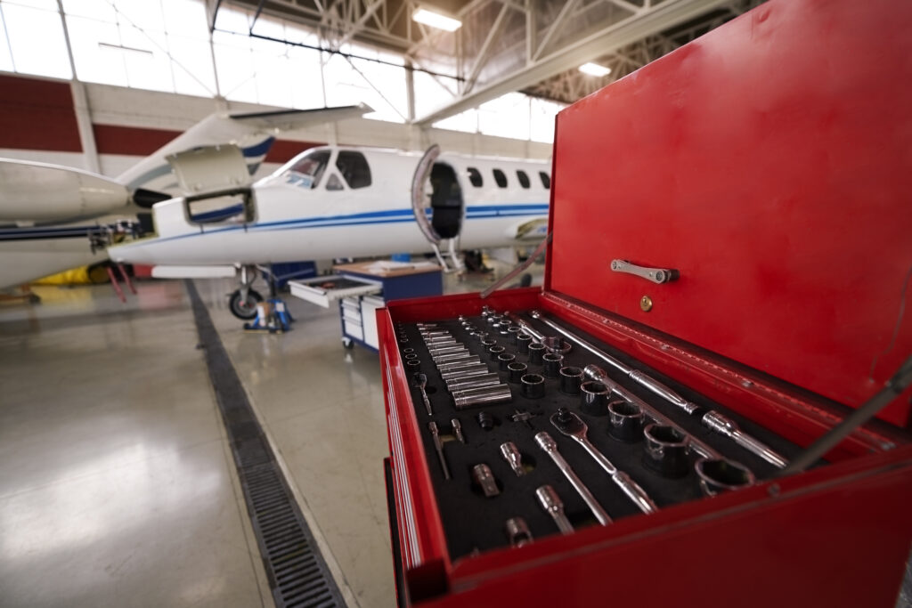 Private jet aircraft in the hangar behind the toolbox open for regular maintenance service