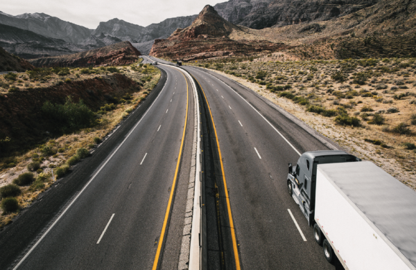 Semitruck with trailer driving down an empty highway